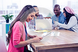 Happy young businesswoman using digital tablet