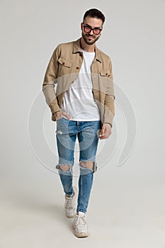 Happy young casual man in jacket walking and smiling