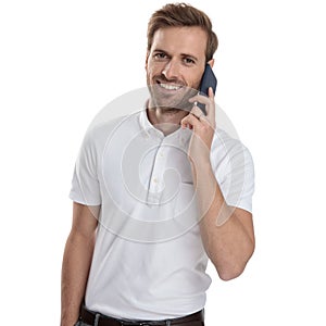 Happy young casual man is talking on his mobile phone