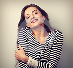 Happy young casual woman hugging herself with natural emotional