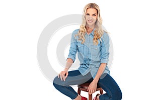 Happy young casual woman in jeans clothes sitting on chair