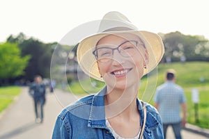 Happy young caucasian bald woman in hat and casual clothes enjoying life after surviving breast cancer. Portrait of beautiful