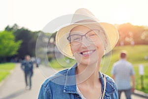 Happy young caucasian bald woman in hat and casual clothes enjoying life after surviving breast cancer. Portrait of beautiful