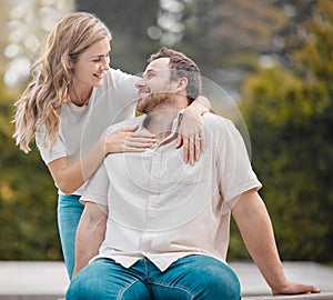 Happy young caucasian couple bonding together during a day outdoors in the garden. Beautiful smiling woman holding and