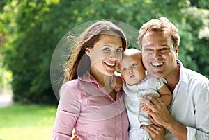 Happy young caucasian family holding baby photo