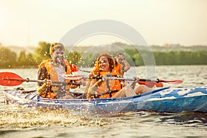 Contento amici kayak sul un fiume tramonto sul 