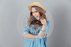 Happy young caucasian lady pointing at you