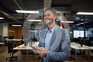 Happy young caucasian man in businesswear smiling while using mobile phone in office photo