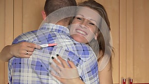 Happy young caucasian woman embracing man after positive pregnancy test