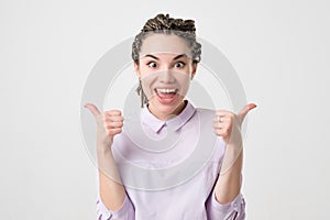 Happy young caucasian woman giving thumbs up on white background