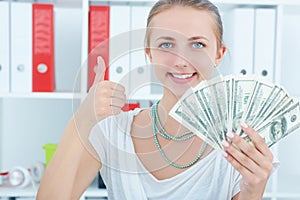 Happy young Caucasian woman with money. Saving account concept.