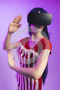 Happy young caucasian woman using a virtual reality headset medium studio shot magenta background