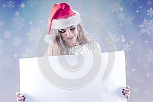 Happy young christmas girl holding a blank paper sign.