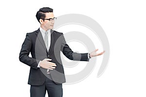Happy young confident asian businessman with eyes glasses in formal black suit showing hand blank area for advertisement, sign,