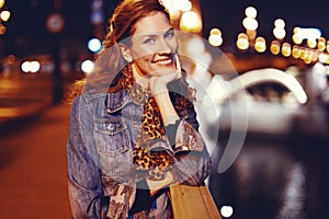 Happy young confident urban woman toothy smile on bridge at night