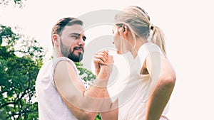 Happy young couple arm restling in the park