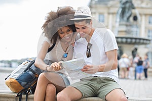 Happy young couple as tourists with map