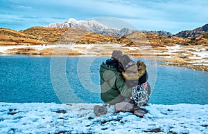 Happy young couple on the background of snowy mountains