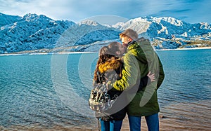 Happy young couple on the background of snowy mountains