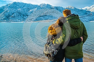 Happy young couple on the background of snowy mountains