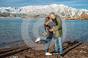 Happy young couple on the background of snowy mountains