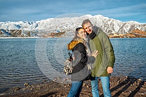 Happy young couple on the background of snowy mountains