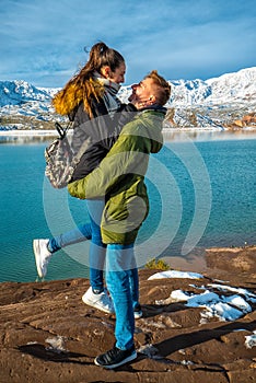 Happy young couple on the background of snowy mountains