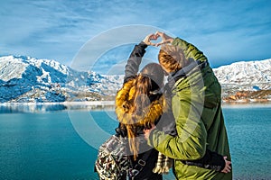 Happy young couple on the background of snowy mountains