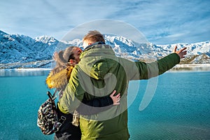 Happy young couple on the background of snowy mountains