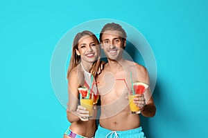 Happy young couple in beachwear with cocktails