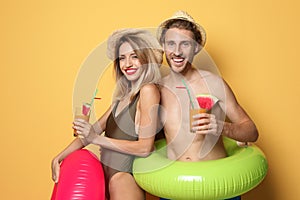 Happy young couple in beachwear with inflatable rings