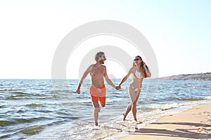 Happy young couple in beachwear running together