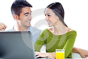 Happy young couple browsing internet at home