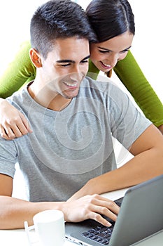 Happy young couple browsing internet at home