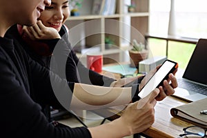 Happy young couple browsing internet on smartphone gadgets together at home