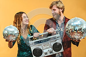 Happy young couple celebrating holidays listening music with boombox