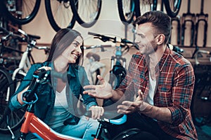 Happy Young Couple Chooses Kids Bicycle in Store