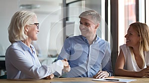 Happy young couple handshake broker making insurance investment bank deal photo