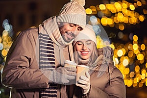 happy young couple with coffee in christmas city