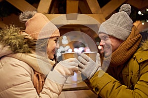 Happy young couple with coffee at christmas market