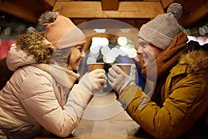 Happy young couple with coffee at christmas market