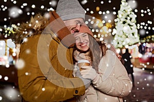 Happy young couple with coffee at christmas market