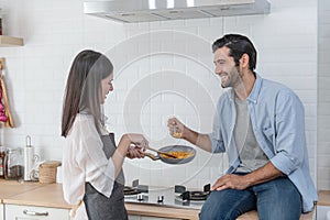 Happy young couple cooking together in the kitchen at home