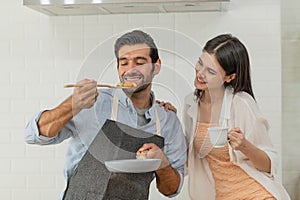 Happy young couple cooking together in the kitchen at home