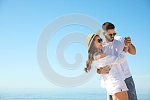 Happy couple dancing at beach near sea. Honeymoon trip