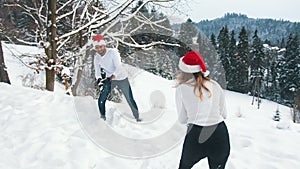 Happy young couple dancing with christmas lights and santa hats. Love and affection during the christmas eve