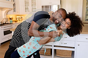 Happy young couple dancing in the kitchen