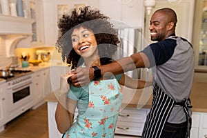 Happy young couple dancing in the kitchen