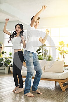 Happy young couple  dancing in living room at home