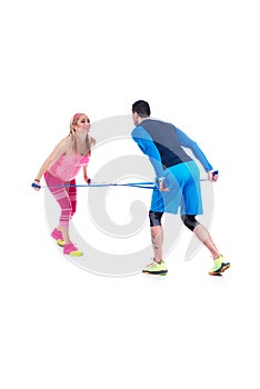 Happy young couple doing exercise in pair with elastic rubber for pregnancy on the white background